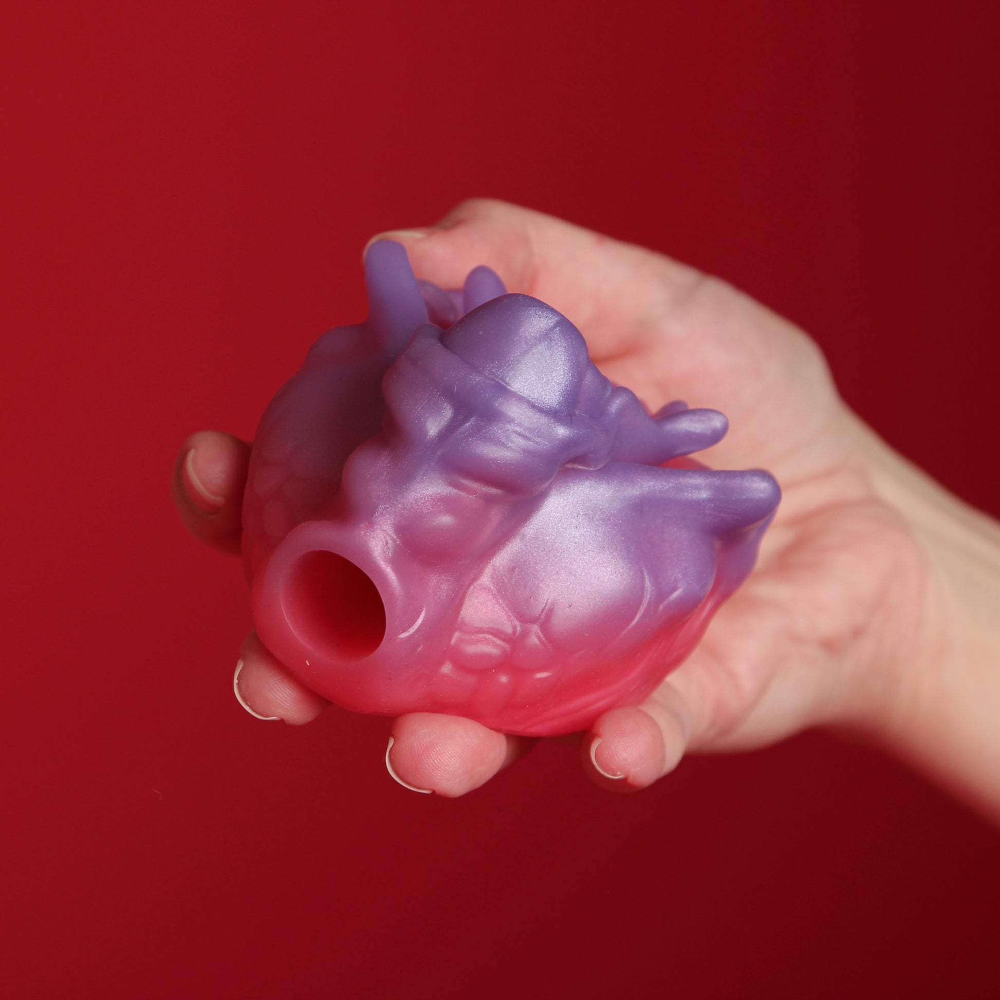 Raido Ginder sivusta kuvattuna punaista taustaa vasten.