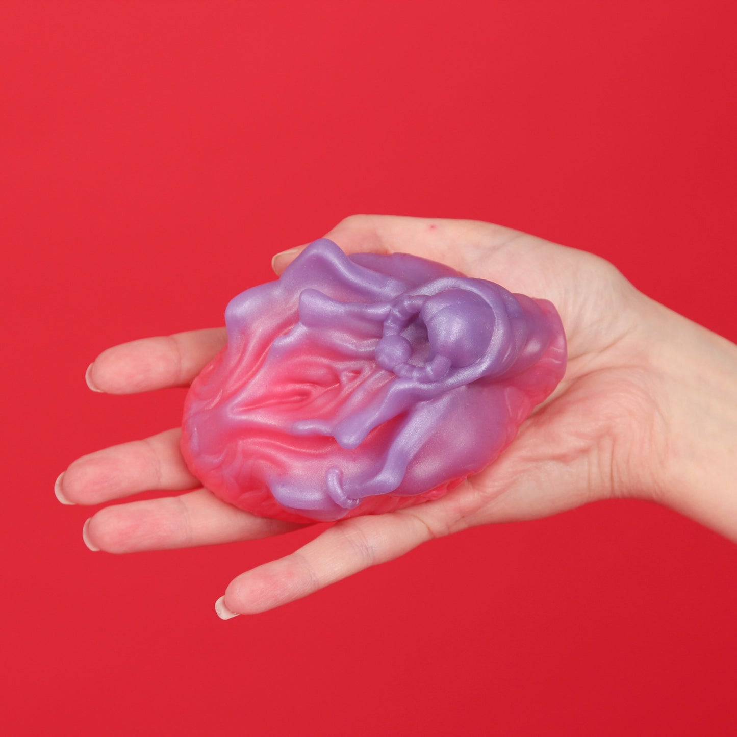 Grinder kädessä punaista taustaa vasten