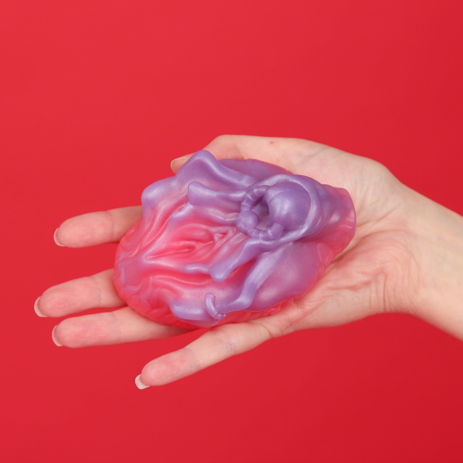 Grinder kädessä punaista taustaa vasten