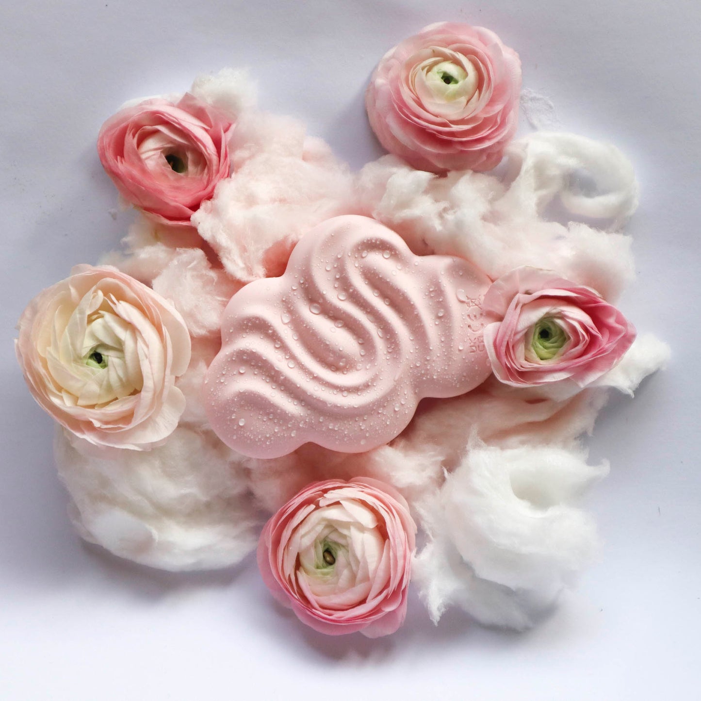 Pilven muotoinen vibraattori kuvattuna untuvan ja ruusujen keskellä. Kaunis muotoilu. Materiaalina pehmeä silikoni.